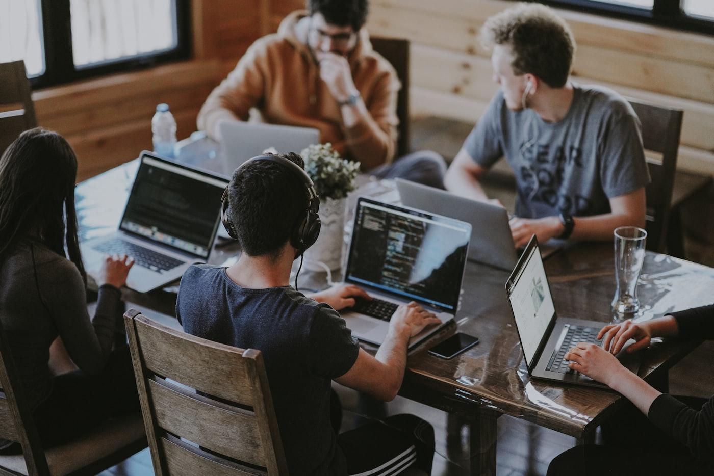 Equipa da Aitra a colaborar com computadores portáteis num espaço de trabalho